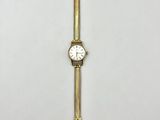 a close up of a gold wrist watch on a white surface