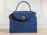 a blue handbag sitting on top of a wooden table