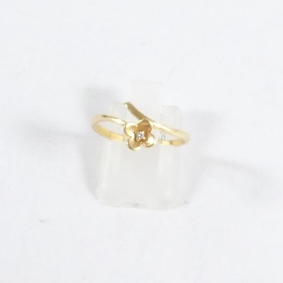 Gros plan sur une bague en or ornée d'une fleur