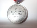 a silver medal with a red ribbon around it