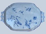 a blue and white platter with flowers and birds on it