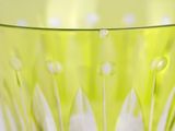 a green bowl with white flowers inside of it
