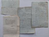 several pieces of old paper with writing on them sitting on a table