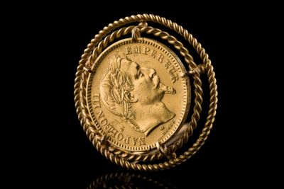 a close up of a gold coin with a rope around it