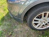 a cat that is sitting on the tire of a car