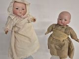 two dolls that are sitting next to each other on a table