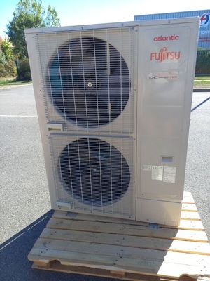 un climatiseur posé sur une palette dans un parking