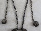 un gros plan d'un collier avec une pièce suspendue à une chaîne