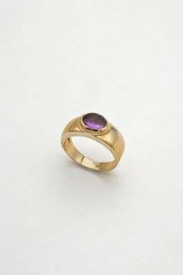 une bague en or sertie d'une pierre violette
