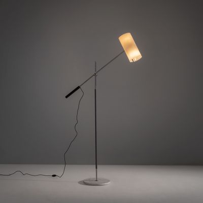 une lampe posée sur une table, avec un cordon qui passe devant