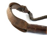 a brown leather belt with a wooden handle on a white surface