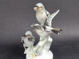 a figurine of two birds perched on a tree branch