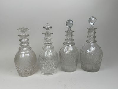 three clear glass decante bottles with silver tops and a silver stopper