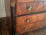 a wooden chest of drawers with a clock on top of it
