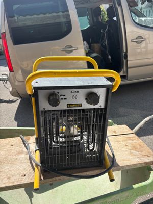 un petit radiateur portable posé sur une table devant une camionnette