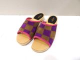 une paire de chaussons violets et marron posés sur une surface blanche