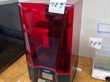 une imprimante 3D rouge et noire posée sur une table