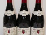 trois bouteilles de vin rouge sont alignées sur une table
