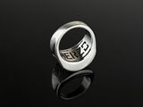 a close up of a silver ring on a black surface