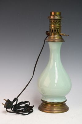 une lampe en verre vert clair munie d'un support métallique