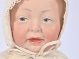 a baby doll that is wearing a bonnet and a dress