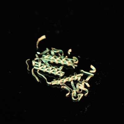 a close up of a chain on a black surface with a black background