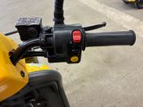 a close up of the handlebars on a yellow motorcycle