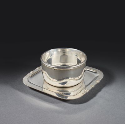 une tasse et une soucoupe en argent posées sur un plateau