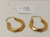 deux paires de boucles d'oreilles créoles en or posées sur une surface blanche, accompagnées d'une étiquette de prix
