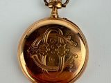 an old gold pocket watch with a picture of a woman on it