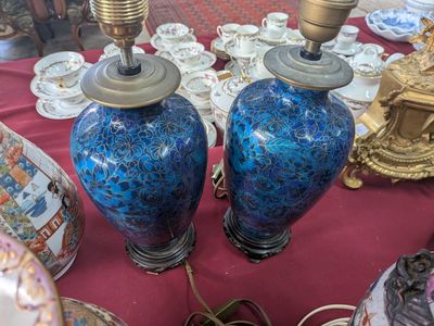 two blue vases sitting on a table with a red table cloth