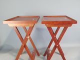 deux tables pliantes en bois, posées contre un mur et surmontées de plateaux