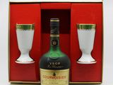 a bottle of courvoisier and two cups in a box