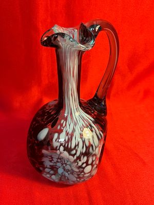 un vase en verre posé sur un tissu rouge