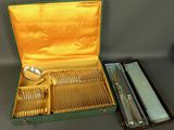 silverware in a green case on a table with other silverware in it