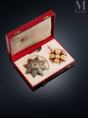 a red box with a silver medal and other items in it