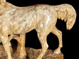 a statue of a horse that is standing on a rock