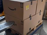 boxes on a pallet in a warehouse with a hand truck in the background