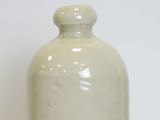 a white vase sitting on a table with a white background