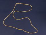 un collier en or avec une chaîne en or sur fond bleu