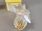 perfume bottle in the shape of a fish with a yellow box in the background