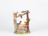a figurine of a well with birds on it