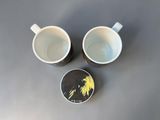 two coffee cups sitting next to each other on a table