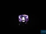 gros plan d'un diamant violet sur une surface noire