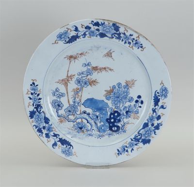 assiette bleue et blanche ornée d'un oiseau et de fleurs