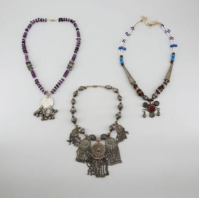 three necklaces and a necklace with a bird on it