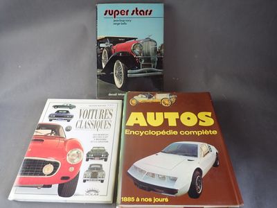 trois livres posés sur une table, à côté d'une voiture rouge et d'une voiture de sport rouge