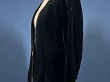 black velvet jacket on a mannequin stand with a blue background