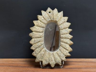 a small mirror sitting on top of a wooden table