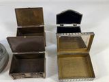 three small metal boxes sitting next to each other on a white surface